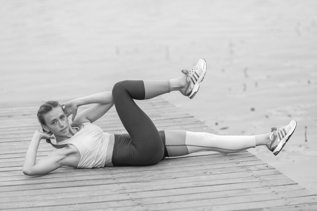 Femme réalisant des exercices abdominaux sur tapis