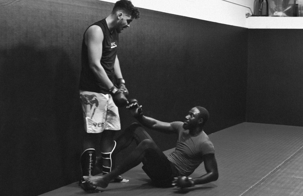 Deux partenaires s’entraident pendant un cours de MMA à Aix-en-Provence