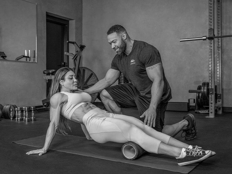 Coach sportif guidant un exercice de mobilité avec foam roller à Aix-en-Provence