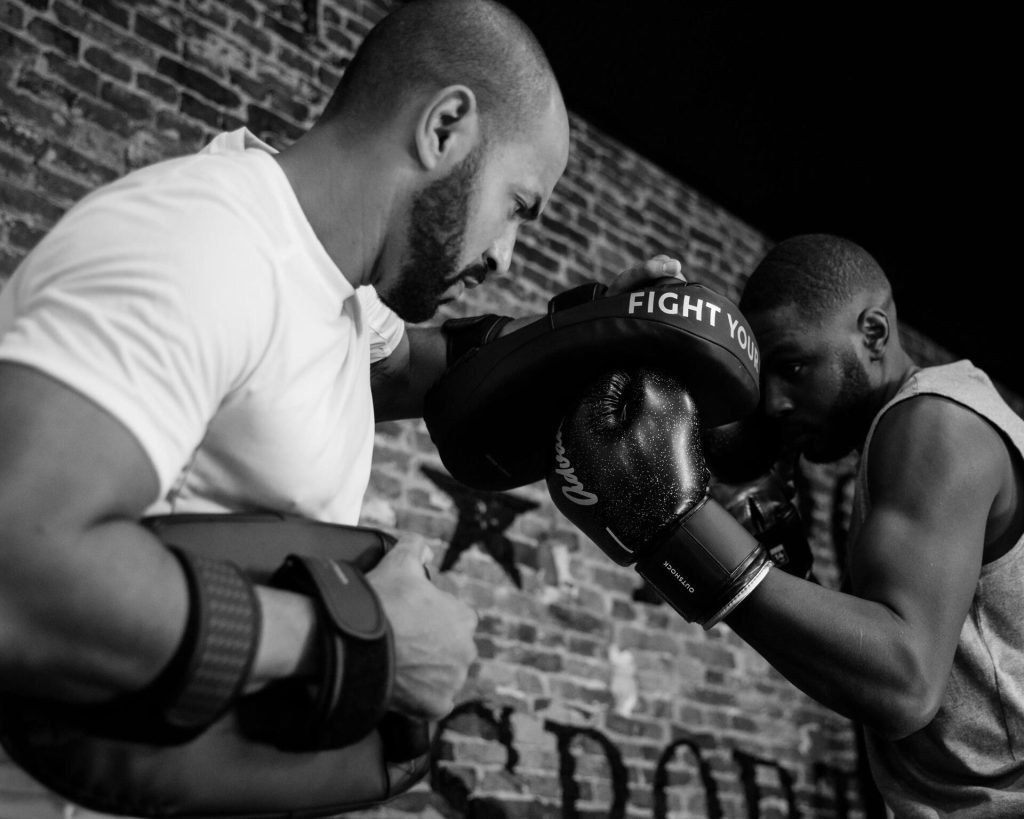Coach de boxe tenant des pattes d’ours pendant un cours privé à Aix-en-Provence