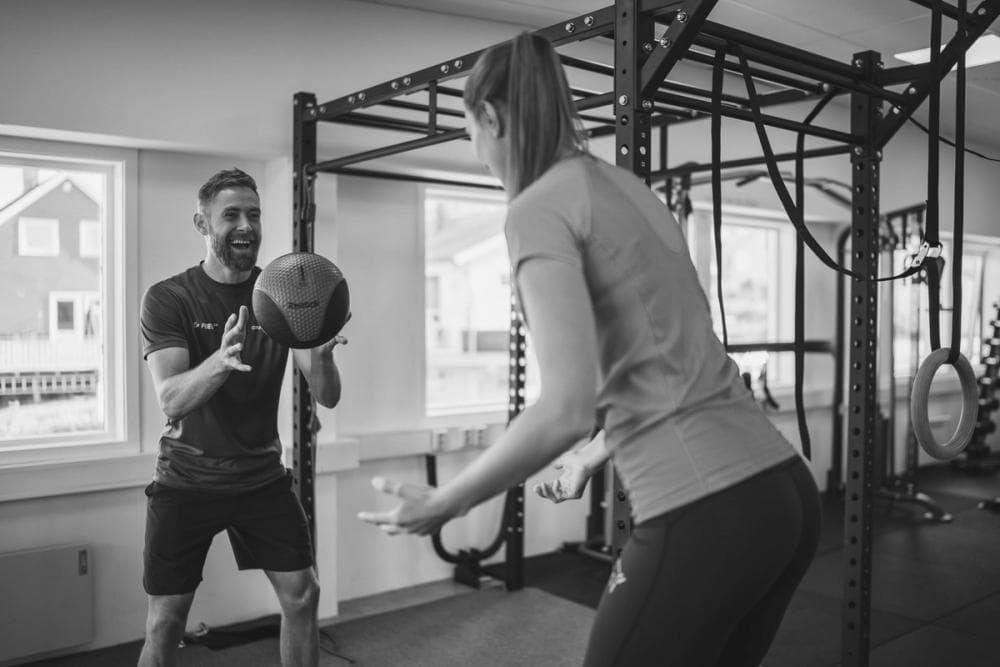 Coach sportif accompagnant une pratiquante avec un medicine-ball à Aix-en-Provence