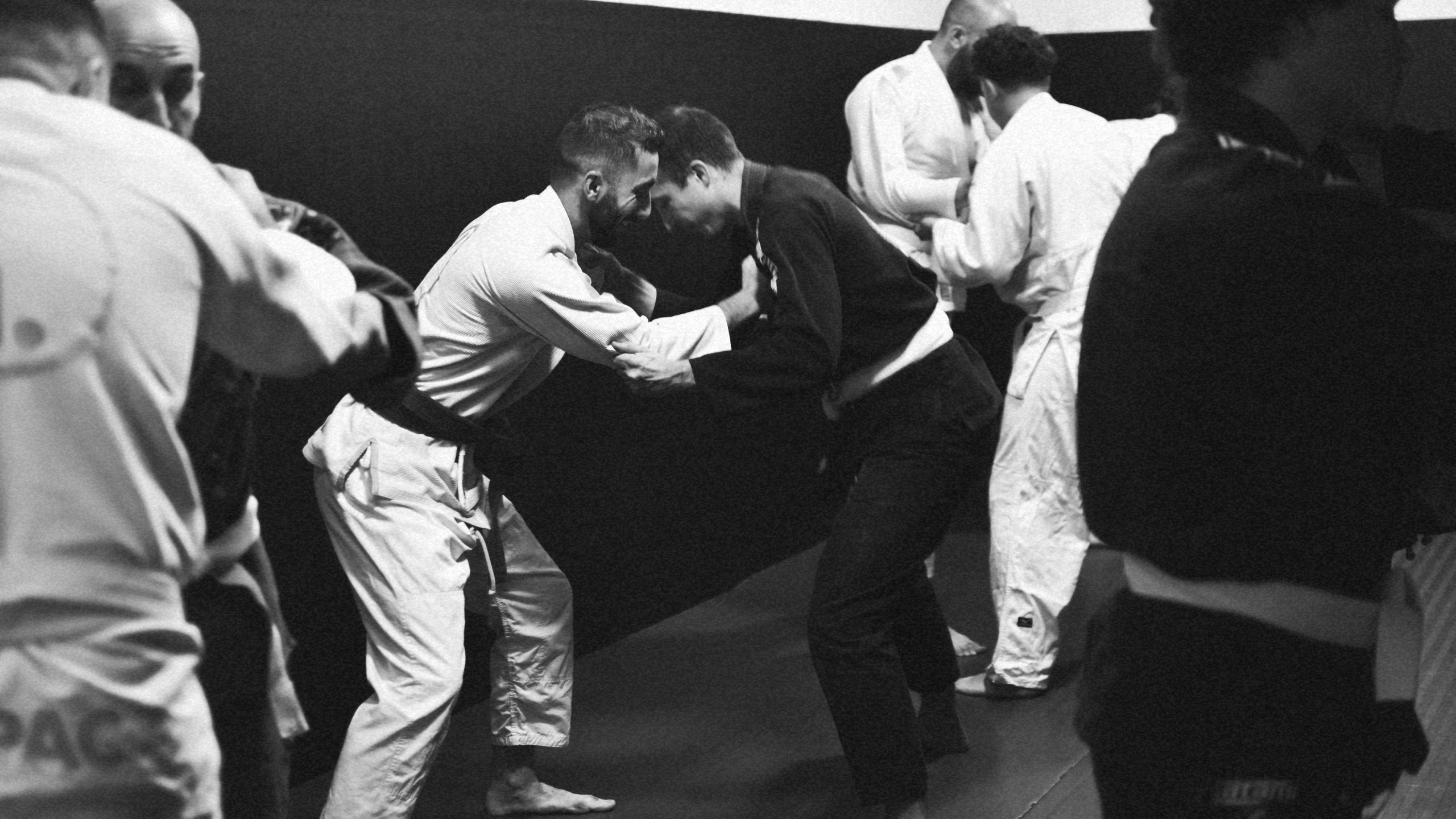 Coach guidant des pratiquants pendant un cours de Jiu-jitsu chez IMPACT