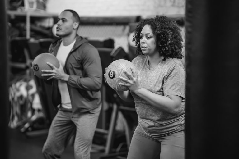 Deux pratiquants réalisent des fentes avec medicine-ball pendant un entraînement fonctionnel à Aix-en-Provence