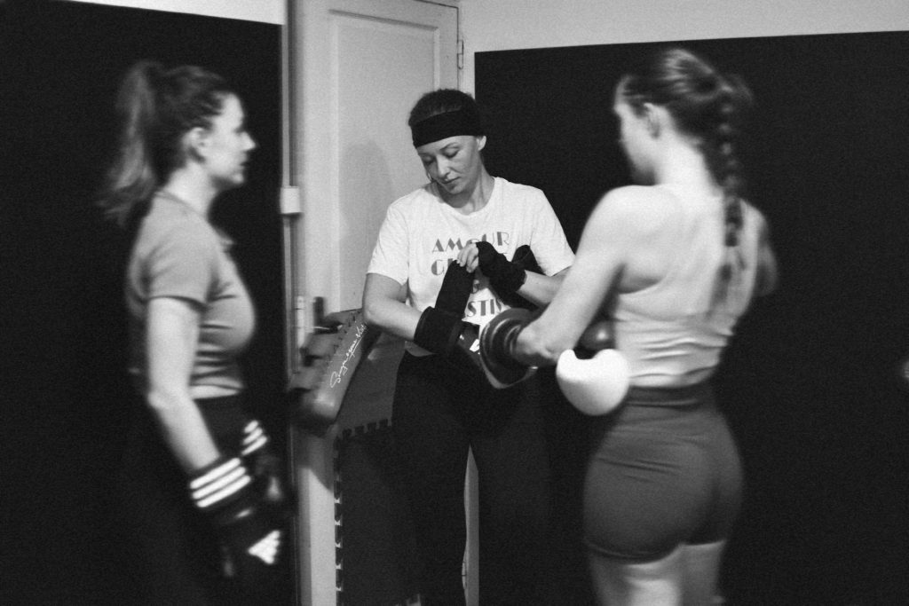 Coach tenant une cible devant deux participantes pendant un cours de Fit Boxing à Aix-en-Provence