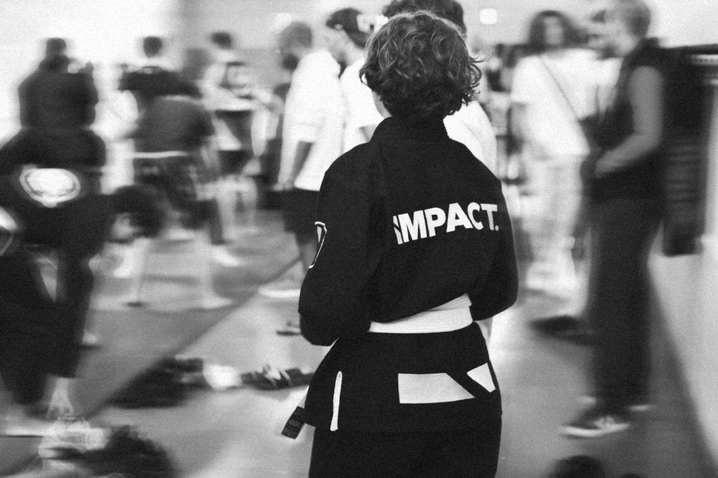 Adolescent de l’équipe IMPACT en kimono lors d’une compétition de jiu-jitsu