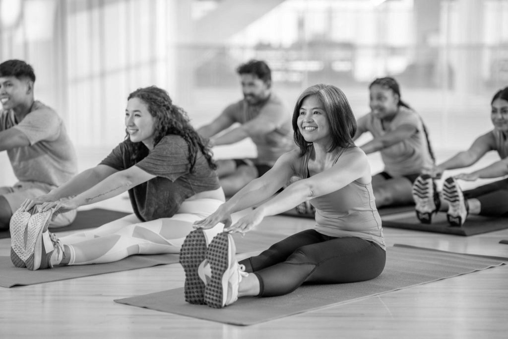 Groupe d’adultes réalisant des étirements pendant un cours de sport collectif