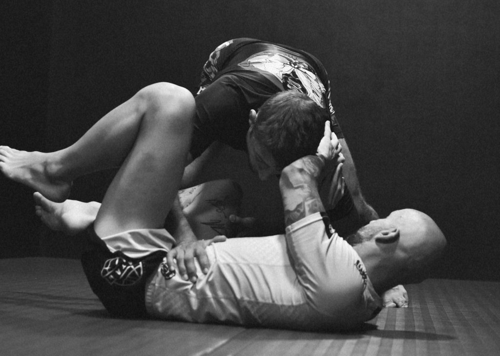 Coach sportif corrigeant une technique de Jiu-jitsu pendant une séance personnalisée à Aix-en-Provence