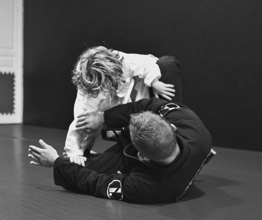 Enfant découvrant une technique de Jiu-jitsu au sol avec son professeur à Aix-en-Provence