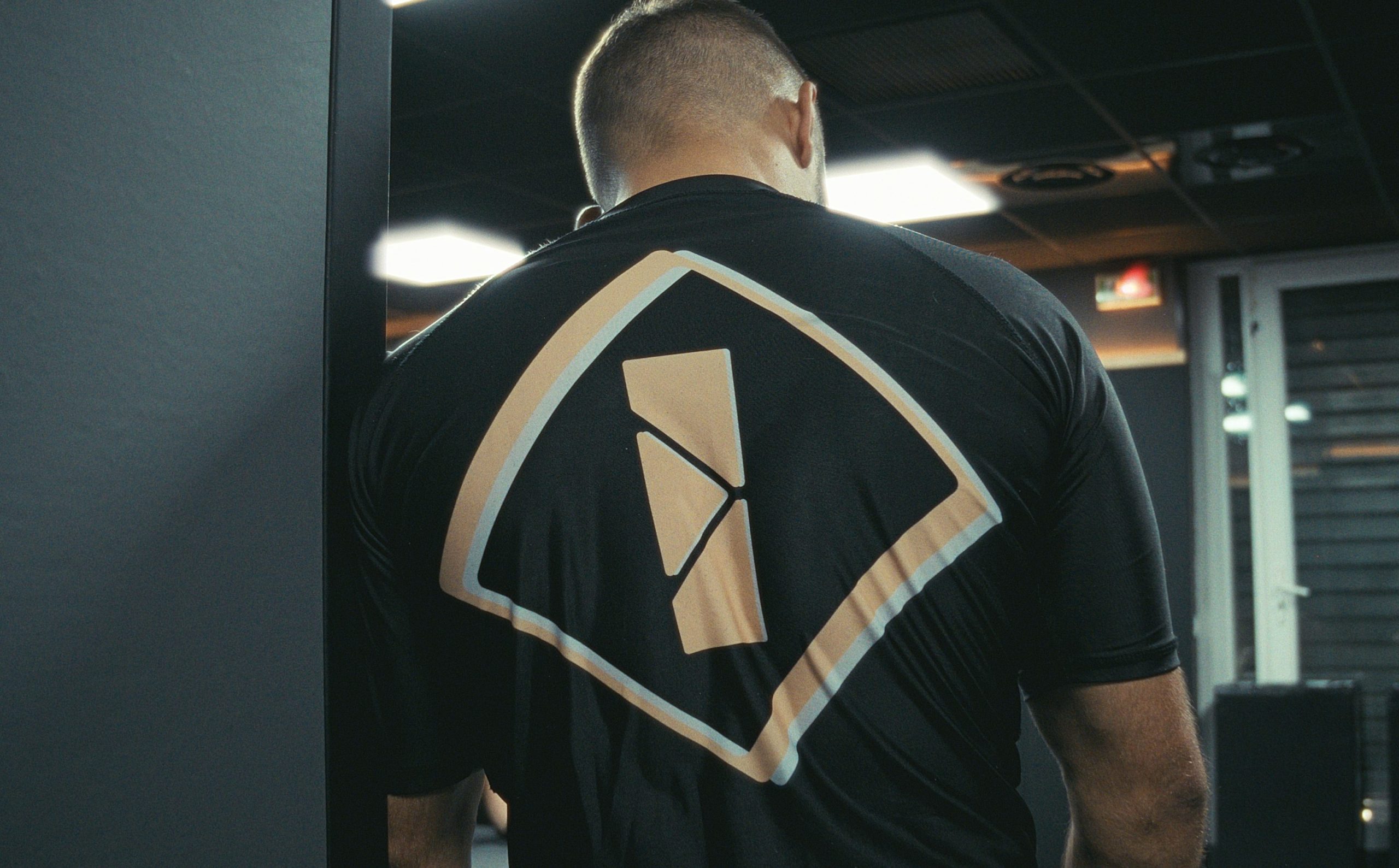 Entraîneur de Jiu-jitsu Brésilien observant ses pratiquants sur les tatamis du club IMPACT à Aix-en-Provence.