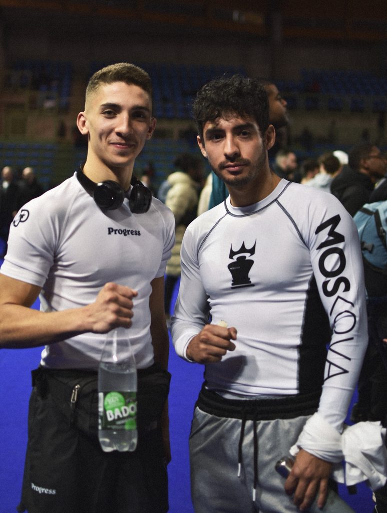 Deux compétiteurs de Jiu-jitsu Brésilien s’hydratent et s’alimentent entre leurs combats lors d’un tournoi.