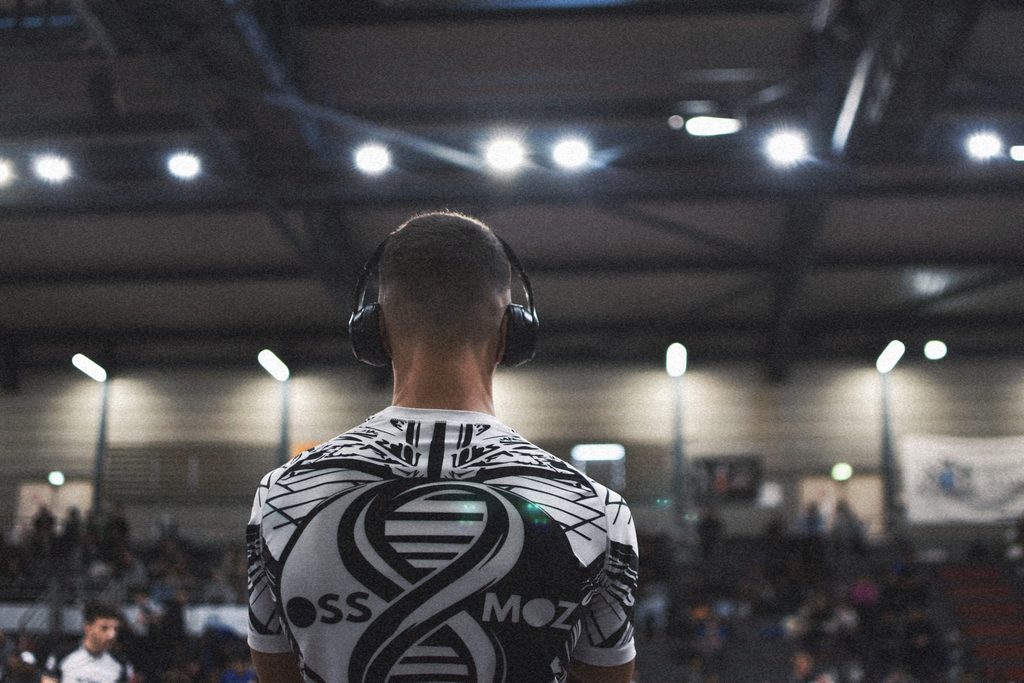 Compétiteur de Jiu-jitsu Brésilien utilisant un casque audio pour s’isoler et récupérer entre deux combats.