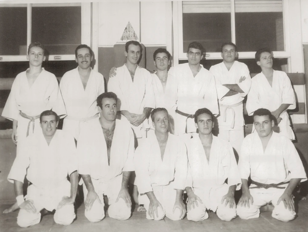 Photographie collective de plusieurs générations de la famille Gracie réunies en kimono, illustrant la transmission familiale du jiu-jitsu brésilien.