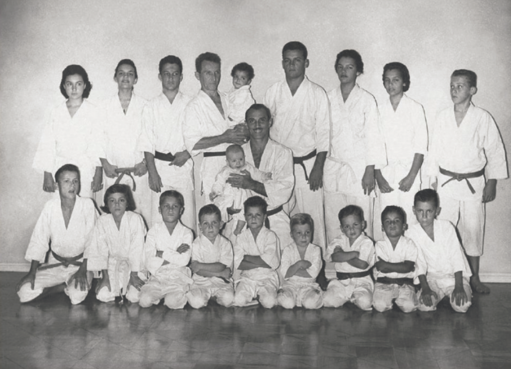 Photographie collective de pratiquants de l’Académie Gracie réunis dans leur salle d’entraînement à Rio de Janeiro dans les années 1950.