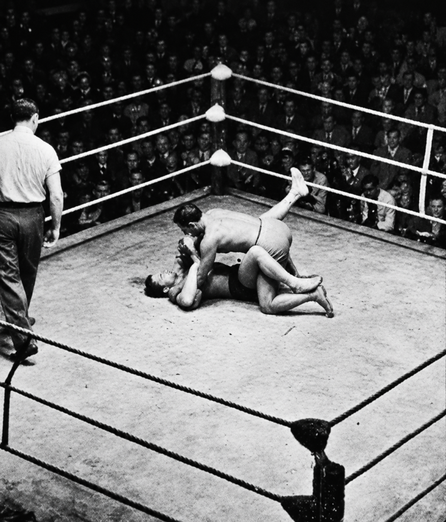 Photographie ancienne d'un combat de jiu-jitsu au sol sur un ring au Brésil, attribuée à une confrontation entre George Gracie et Orlando Américo, dit Dudu, en 1934.