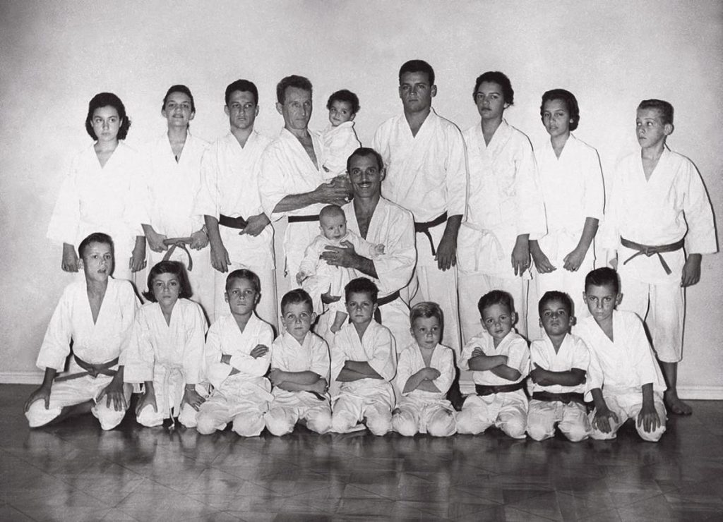 Carlos et Hélio Gracie entourés d’adultes et d’enfants en kimono au Brésil dans les années 1950